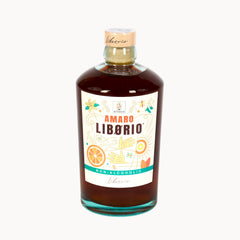 A bottle of Liborio Amaro Liborio non-alcoholic liqueur with amber-brown liquid, a white label with colorful illustrations, and a cork stopper, set against a plain white background.