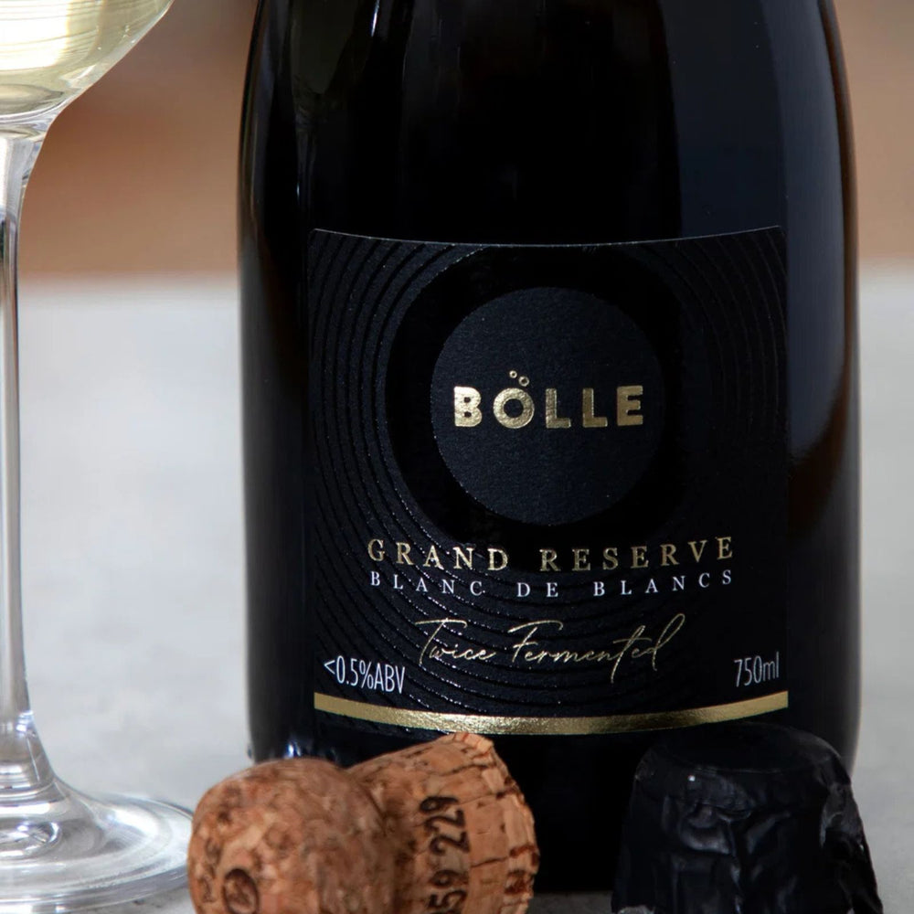 A bottle of Bölle Grand Reserve sparkling wine, featuring a dark glass bottle with a gold seal and gold lettering on the label, set against a plain white background.