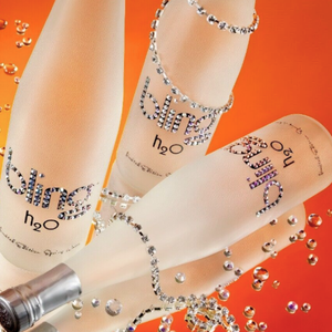 Bottle of Bling h2o with rhinestone embellishments on an orange background