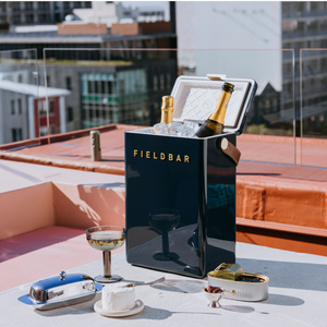 Fieldbar ice bucket with zero proof champagne on a rooftop with cityscape background