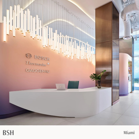 Modern interior with a reception desk and Bosch, Thermador, and GAGGENAU logo on the wall