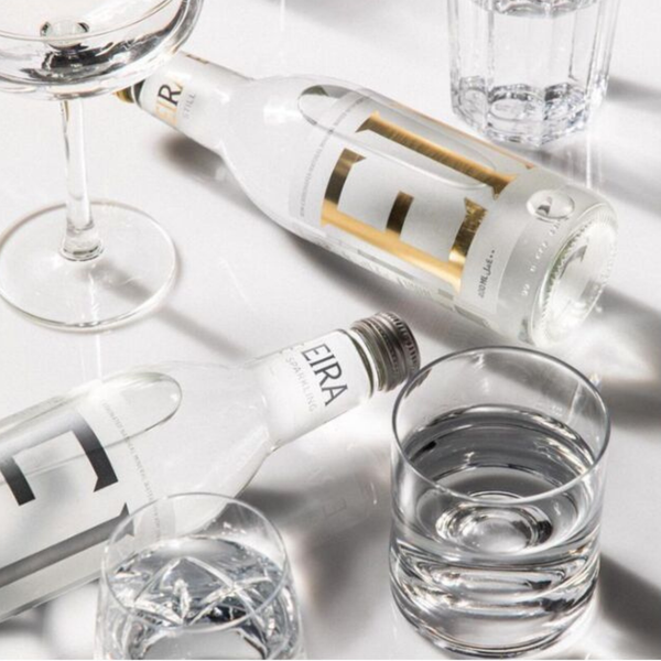 Rienne & EIRA bottles and glasses on a reflective surface