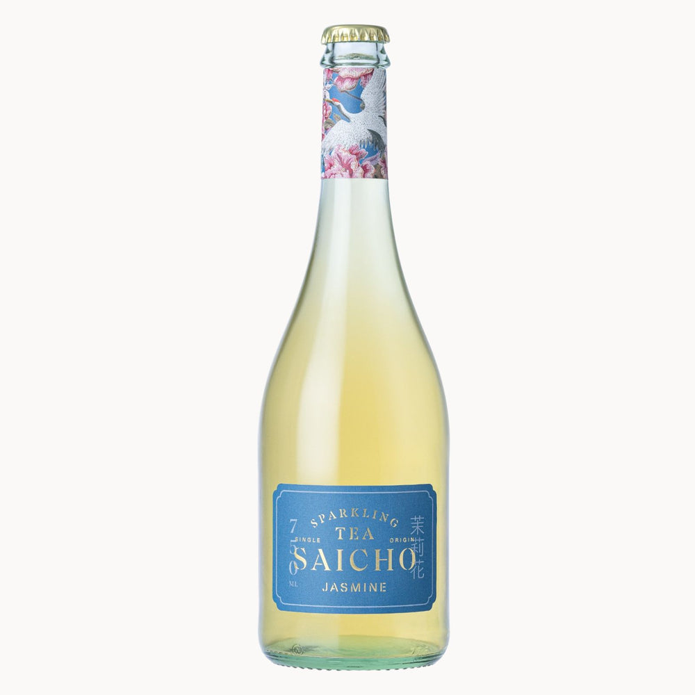A bottle of Saicho Jasmine Sparkling Tea, featuring a pale yellow liquid inside a clear glass bottle with a blue label and a decorative cranes pattern on the neck seal, set against a solid off-white background.