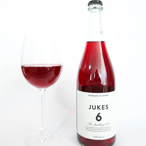 JUKES 6 The Sparkling Red bottle and filled wine glass at RIENNE, non-alcoholic wine alternative, 0.0% alc/vol
